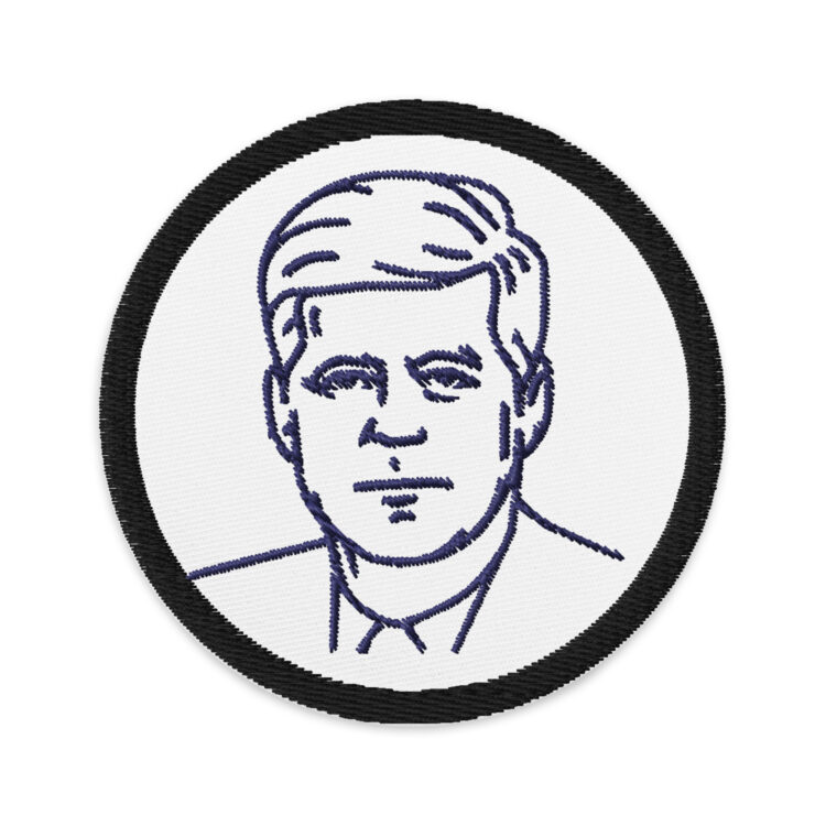 3 inch circle patch with a black outline around a white background with the outline of deceased US president John F Kennedy in navy blue from the front. Centered in the patch. denim and patches