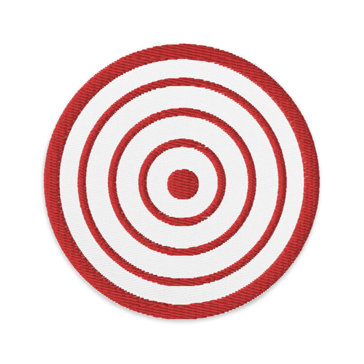 3 inch circle patch with a red outline around a white background. With a red target centered inside the circle. denim and patches