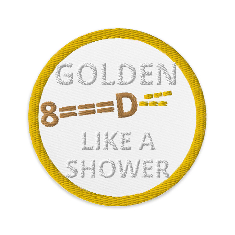 3 inch circle patch with a gold outline around a white background. With the words "GOLDEN LIKE A SHOWER" written inside the circle with the word Golden being separated by the phrase by a typeface peeing penis. The penis being brown and the pee being yellow. denimandpatches